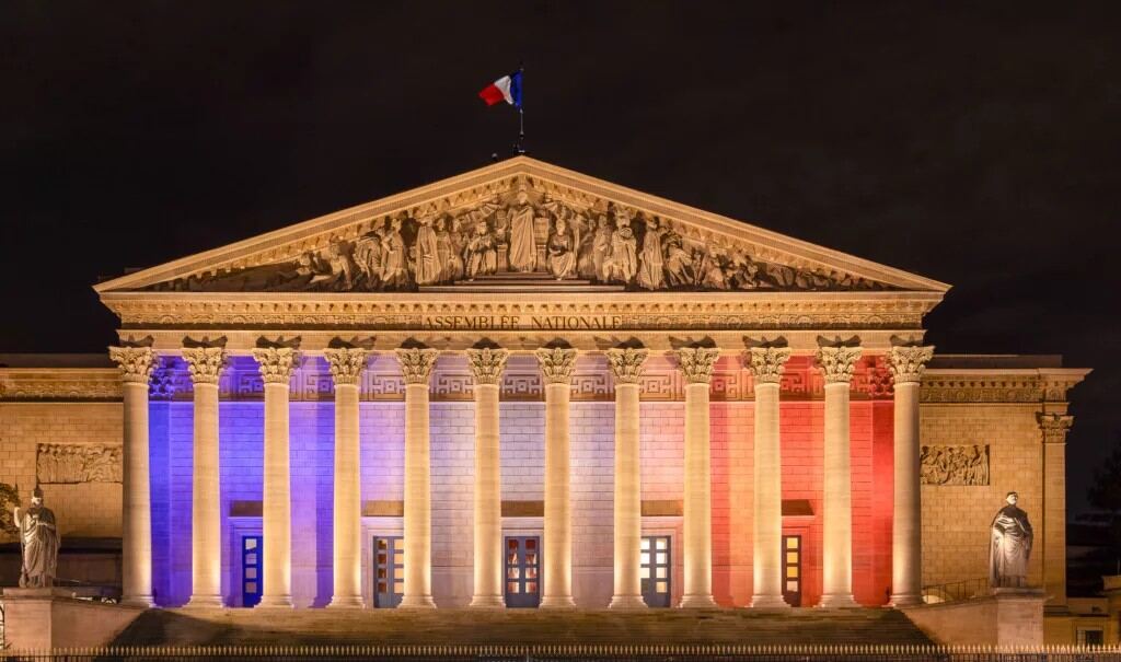 Façade de l'Assemblée nationale illuminée aux couleurs du drapeau français